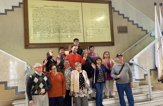 Grupo de adultos mayores en las escaleras del hall de acceso al congreso nacional